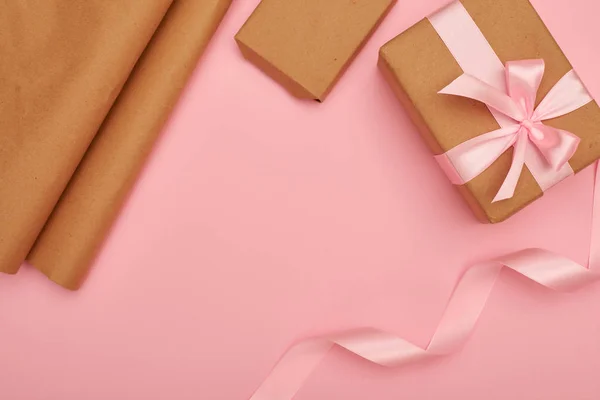 Carino regalo scatola con roba avvolgente su flatlay rosa Foto Stock Royalty Free