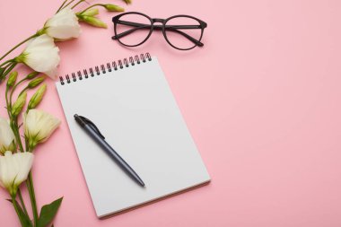 Kadınsı işyeri jotter, gözlük ve pastel çiçeklenir