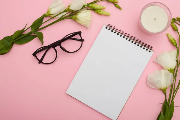 Arbetsytan tabell med glasögon, notebook, blommor och ljus på p — Stockfoto