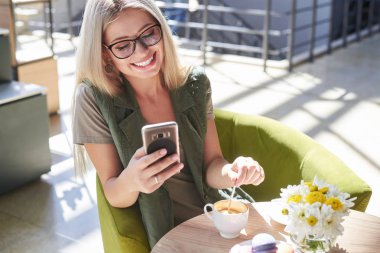 Café'de cep telefonu kullanan güzel kadın