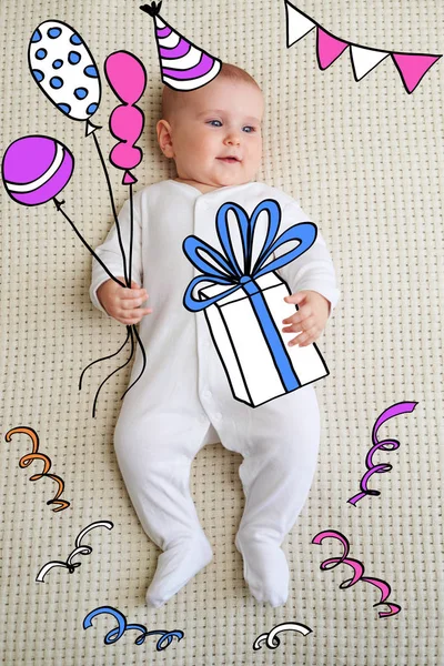 Baby lying on bed with gift box and balloon — Stock Photo, Image
