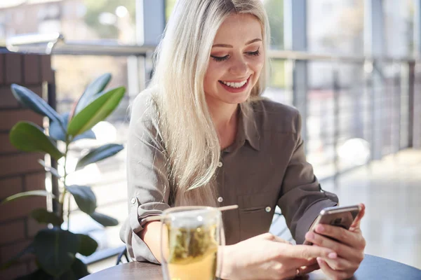 Mooie vrouw met behulp van telefoon in café — Stockfoto