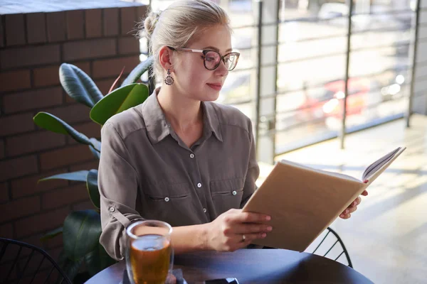 Beautiful woman reading book at cafe — Stock Photo, Image