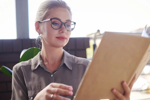 Vrouw die boek leest in café — Stockfoto