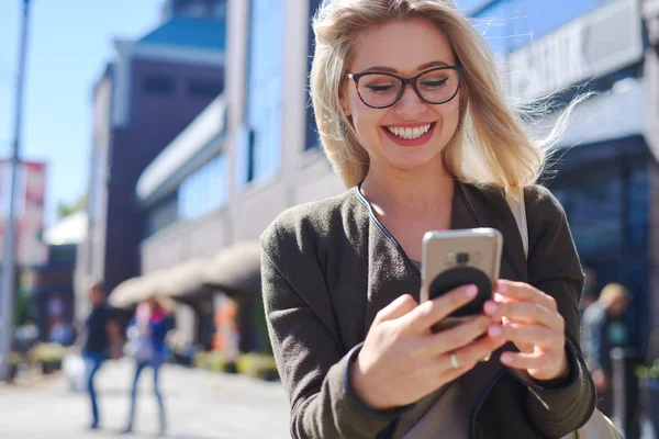 Mujer feliz usando el teléfono móvil en la ciudad —  Fotos de Stock