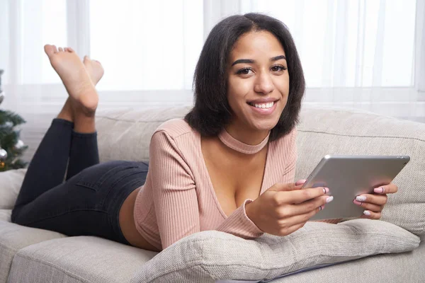 Adolescente utilizando la tableta digital en el sofá —  Fotos de Stock