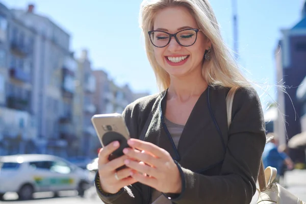 Gelukkige vrouw met behulp van mobiele telefoon in de stad Stockfoto