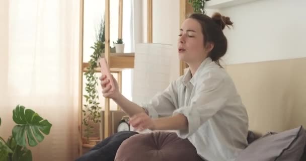 Женщина поет песни и танцы с помощью мобильного телефона дома — стоковое видео