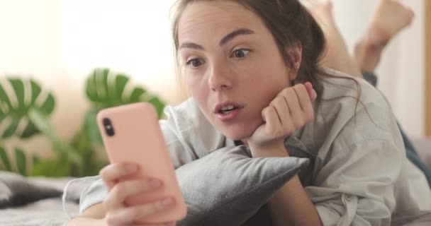 Wanita merayakan kesuksesan online menggunakan telepon di rumah — Stok Video