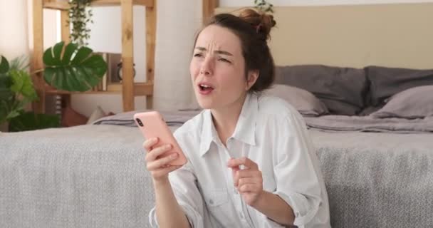 Жінка використовує мобільний телефон і співає пісню вдома — стокове відео