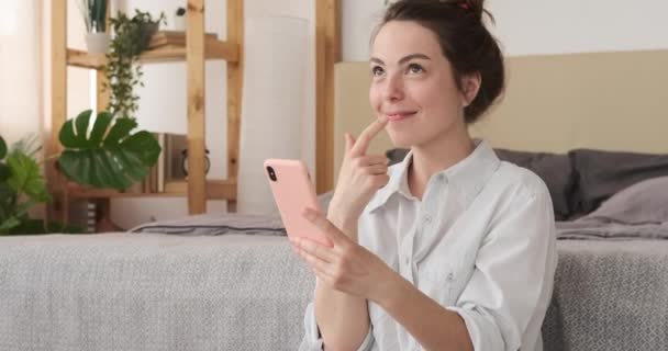 Gelukkig vrouw met behulp van mobiele telefoon thuis — Stockvideo