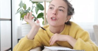 Kadın evde not yazıyor.