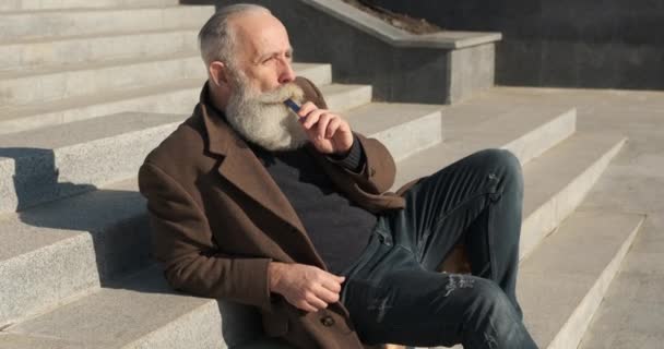 Senior raucht E-Zigarette im Treppenhaus — Stockvideo