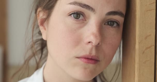 Mujer joven reflexiva sonriendo y mirando a la cámara — Vídeos de Stock