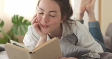 Evde kitap okuyan bir kadın.