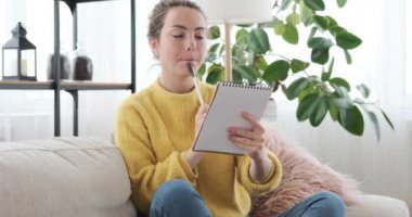 Not defterine yazan düşünceli kadın.