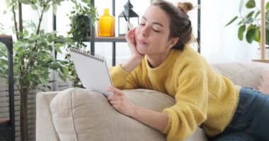 Evdeki not defterine yazan düşünceli kadın.