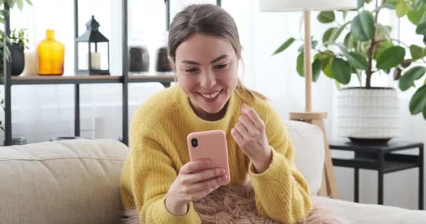 Счастливая женщина с мобильным телефоном дома — стоковое видео