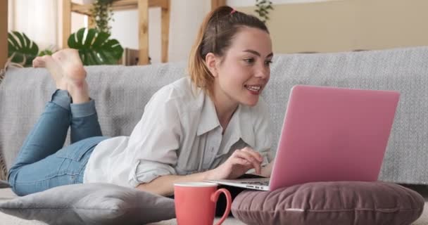 Nő használ laptop feküdt szőnyegen otthon — Stock videók