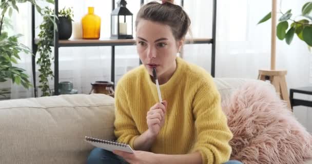 Mujer asombrada escribiendo notas en casa — Vídeo de stock