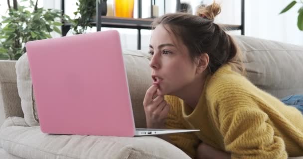 Mulher chocada com a leitura de e-mail usando laptop no sofá — Vídeo de Stock