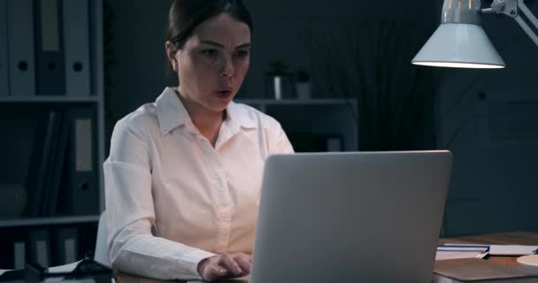 Overworked businesswoman closing laptop late night at office — Stock Video