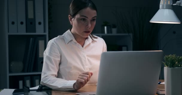 Zakenvrouw afwerking werk op laptop en het verlaten van kantoor 's nachts — Stockvideo