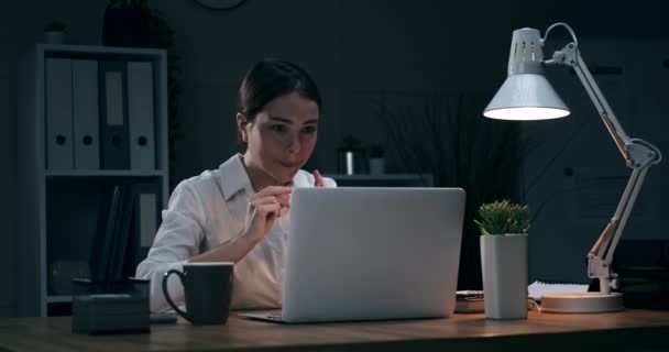 Businesswoman celebrating online success at night office — Stock Video