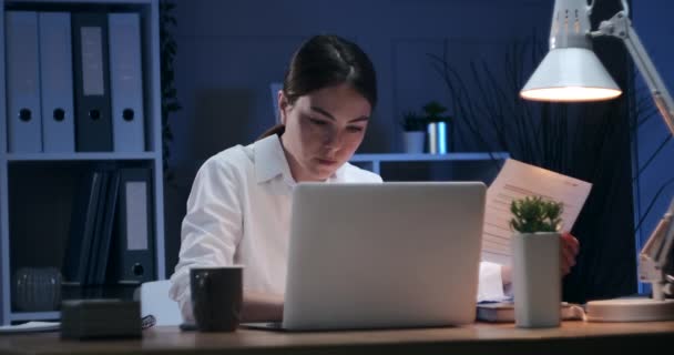 Деловая женщина разговаривает по мобильному телефону во время работы в ночном офисе — стоковое видео