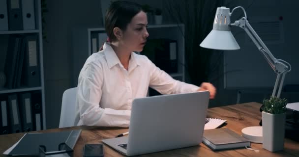 Empresaria hablando por teléfono móvil mientras trabaja en la oficina nocturna — Vídeo de stock