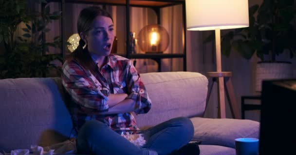 Znudzona kobieta zmienia kanały telewizyjne bez zainteresowania w nocy — Wideo stockowe