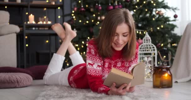 Ontspannen vrouw die thuis een boek leest — Stockvideo