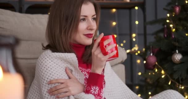 クリスマスツリーでコーヒーを飲む女性を喜ばせます — ストック動画