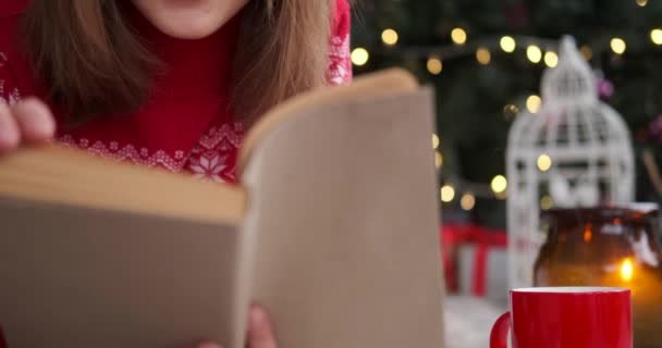 Ung kvinna läser en bok hemma — Stockvideo