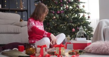 Evde Noel hediyesi paketleyen bir kadın