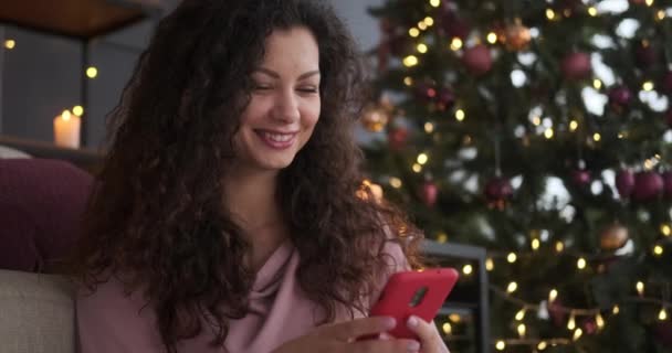 Mujer feliz usando el teléfono móvil durante la víspera de Navidad — Vídeos de Stock