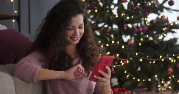 Счастливая женщина с помощью мобильного телефона в канун Рождества — стоковое видео