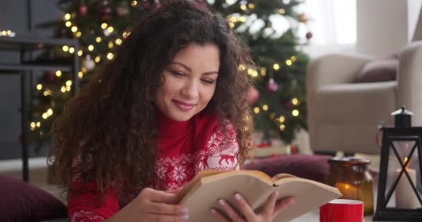 Счастливая женщина читает книгу дома — стоковое видео