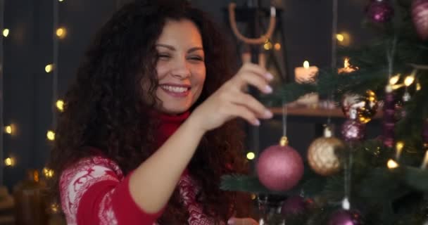 Mujer decorando el árbol de Navidad en casa — Vídeos de Stock
