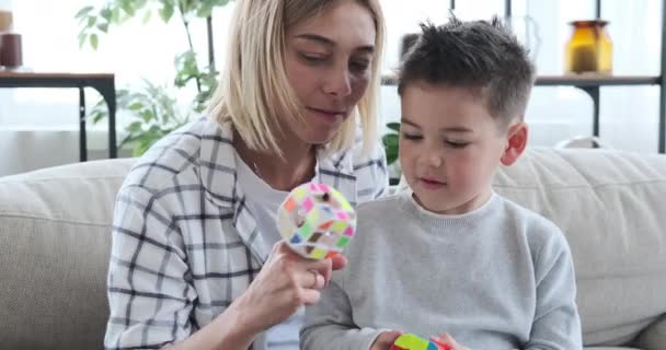 Mutter und Sohn spielen zu Hause mit Rubik-Würfel — Stockvideo