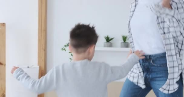 Волнующие мать и сын прыгают на кровати — стоковое видео