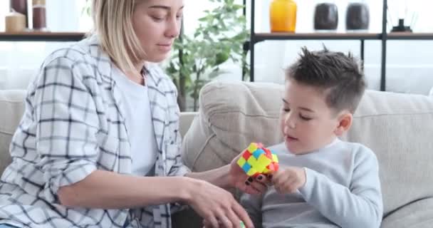 Мать и сын играют с кубиком рубика дома — стоковое видео