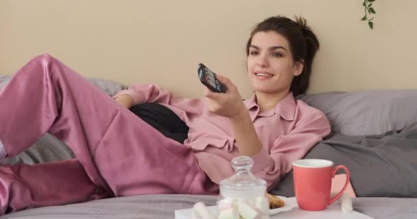 Mulher assistindo tv e tomando café da manhã na cama — Vídeo de Stock