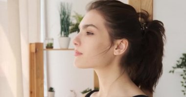 Pencereden bakan ve temiz havanın tadını çıkaran bir kadın.