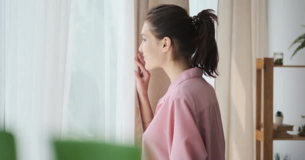 Frau schaut aus Fenster und genießt frische Luft — Stockvideo