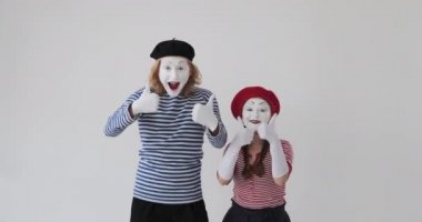 Heyecanlı pandomimci çift başparmak hareketi yapıyor.