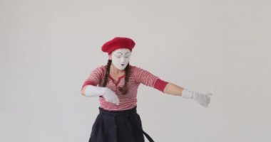 Pandomimci beyaz arka planda dans ediyor