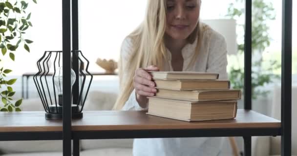 Жінка читає книгу у вітальні — стокове відео