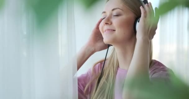 Femme écoutant de la musique à l'aide d'écouteurs — Video