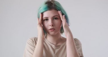 Saçları boyalı bir kadın baş ağrısı çekiyor.